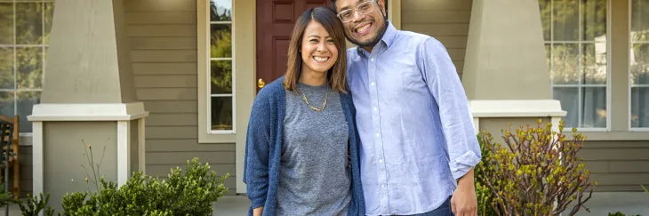 Couple Smiling in front of their home