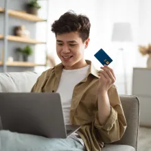 Man holding credit card using laptop