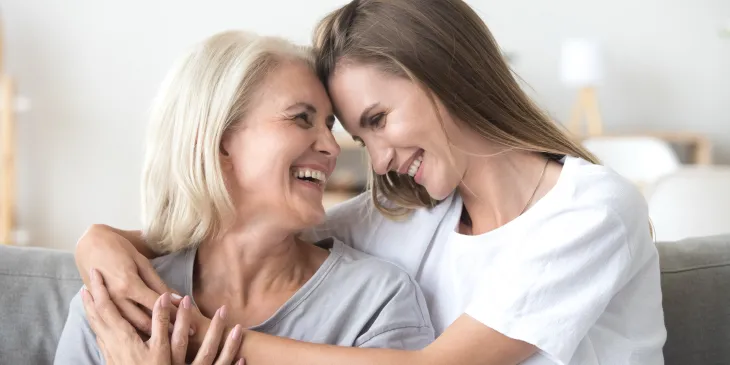 Mother and daughter smiling while embracing