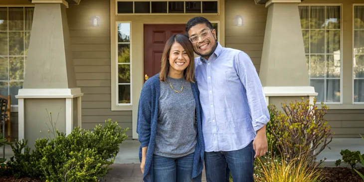 Couple Smiling in front of their home
