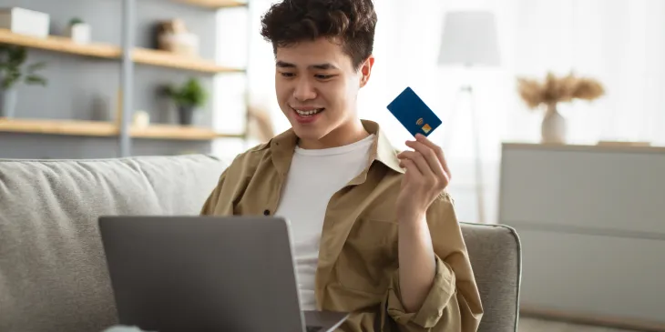 Man holding credit card using laptop