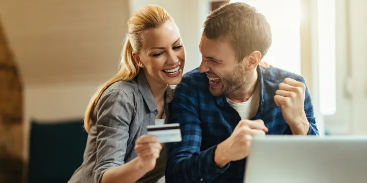 happy-couple-celebrating-while-using-credit-card-a-2023-02-24-19-17-08-utc.jpg