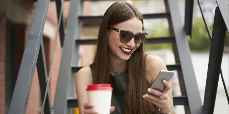 Woman drinking coffee and on the phone - Extraco Banks