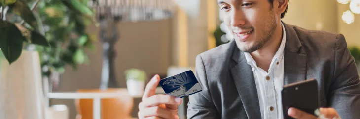 Business man looking at debit card