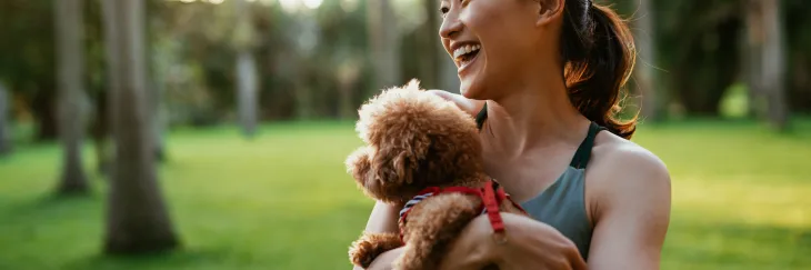 Girl holding dog at park