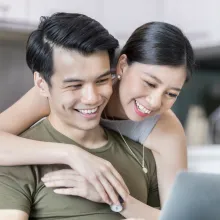 Couple Smiling While using laptop