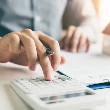 Man using calculator and looking over paperwork