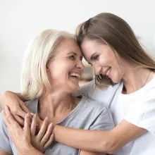 Mother and daughter smiling while embracing