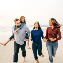 Family on vacation running on beach