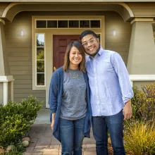 Couple Smiling in front of their home