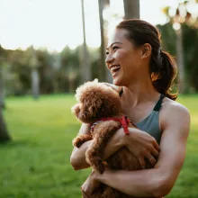 Girl holding dog at park