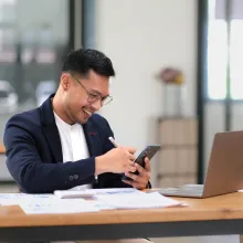 Male business owner looking at iphone - Extraco Banks