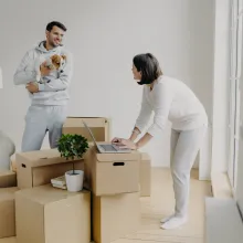 Woman using laptop on top of moving boxes - Extraco Banks