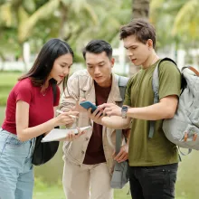 College students looking at phone - Extraco Banks