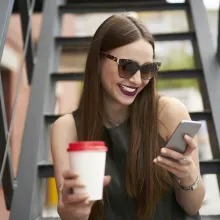 Woman drinking coffee and on the phone - Extraco Banks