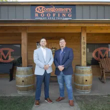 An Extraco employee stands next to the President of Montgomery Roofing
